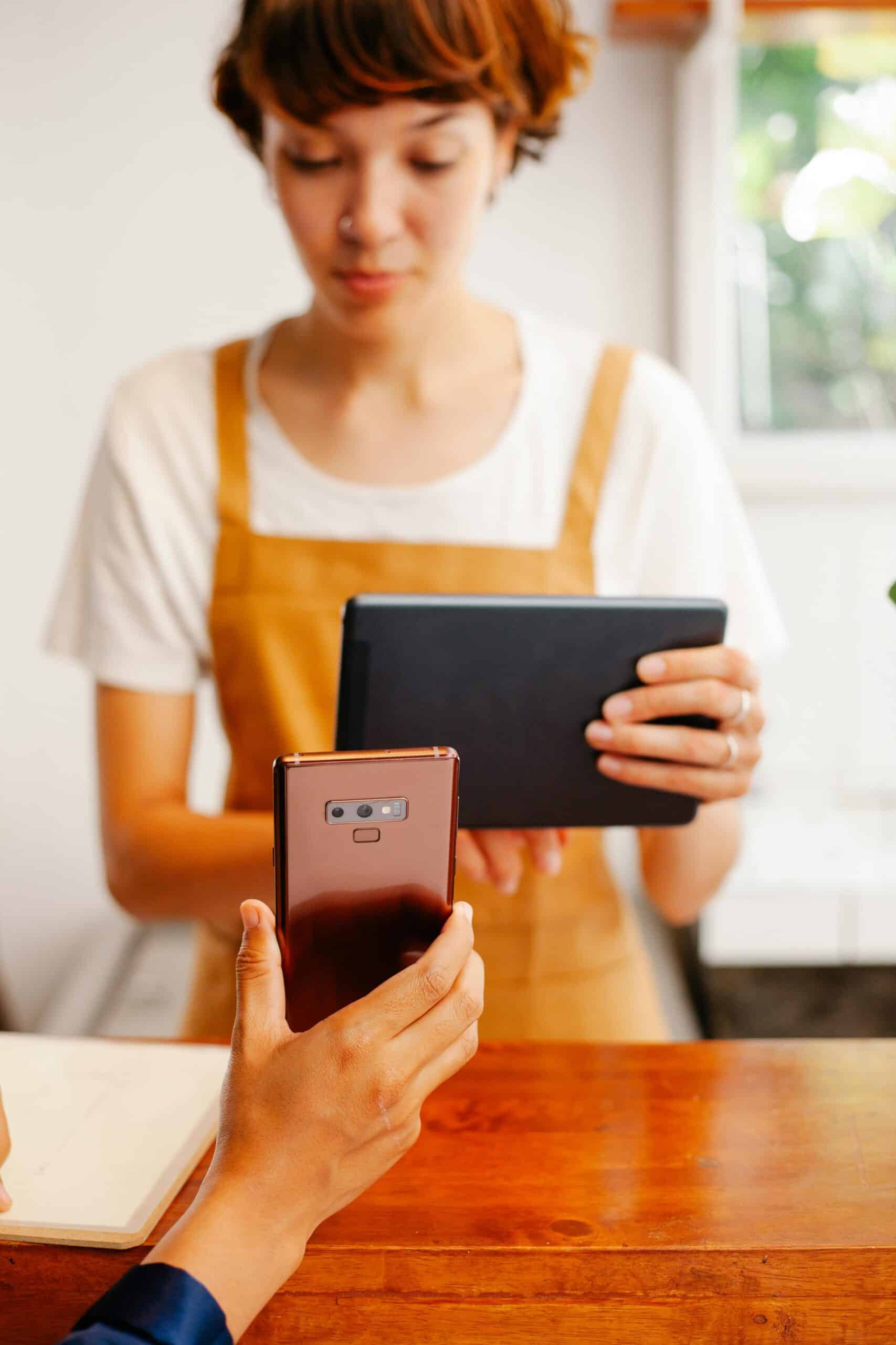 Vrouw met een tablet, hand met een smartphone